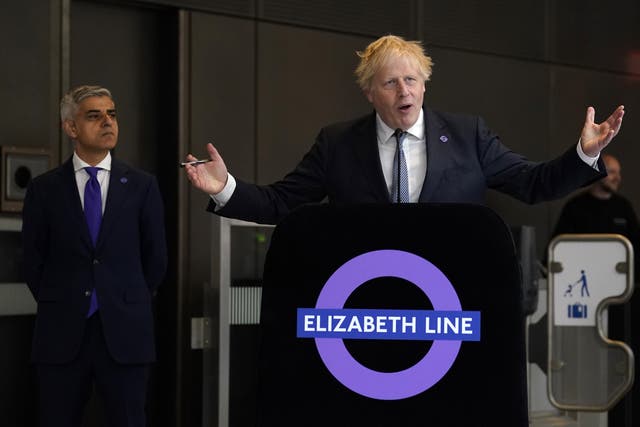 <p>Mayor of London Sadiq Khan looks on as Boris Johnson speaks at the completion of the Elizabeth line in 2022 (Andrew Matthews/PA)</p>