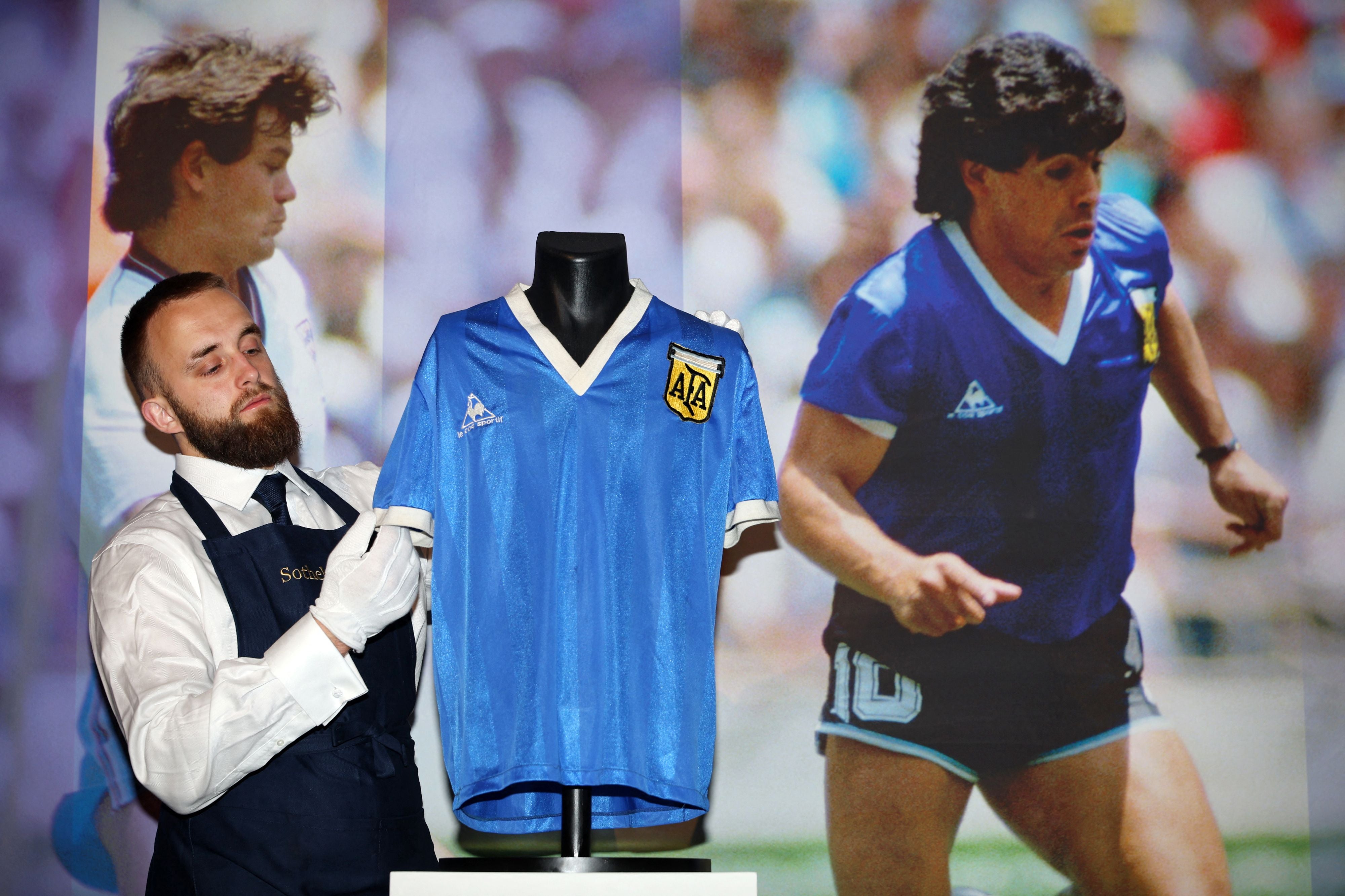 A Sotheby's technician adjusts the shirt worn by Argentina's Diego Maradona during the 1986 World Cup quarter-final match against England