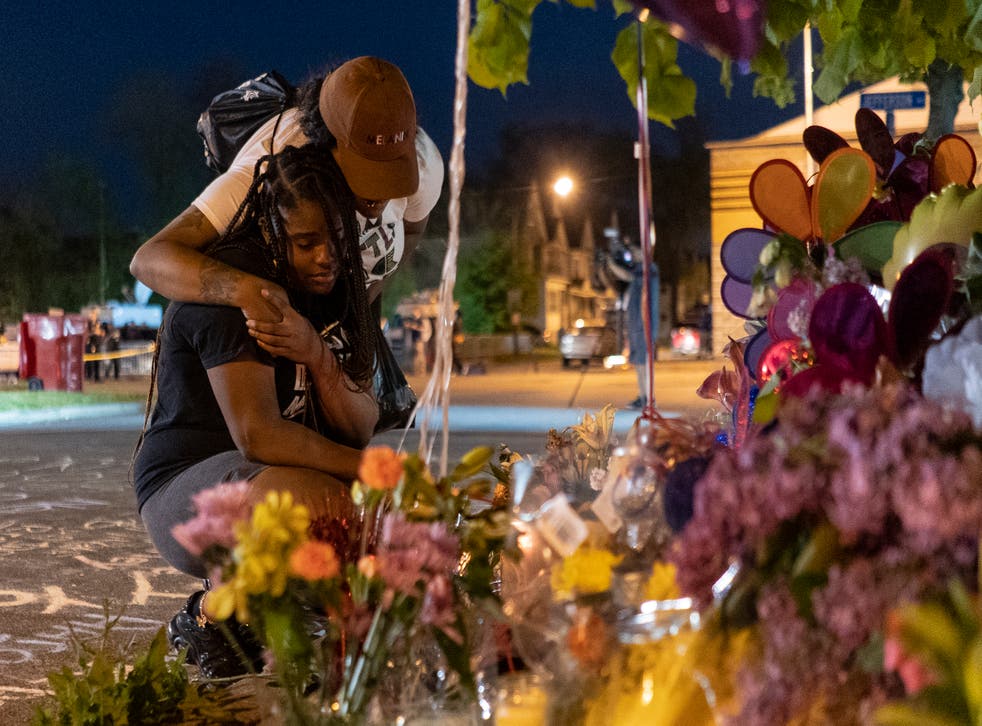 <p>Pleazant Davis, 22, is comforted by her friend, Tasha Dixon, 35, at a memorial honouring the victims of the Tops shooting across the street from the store in Buffalo on 15 May </p>