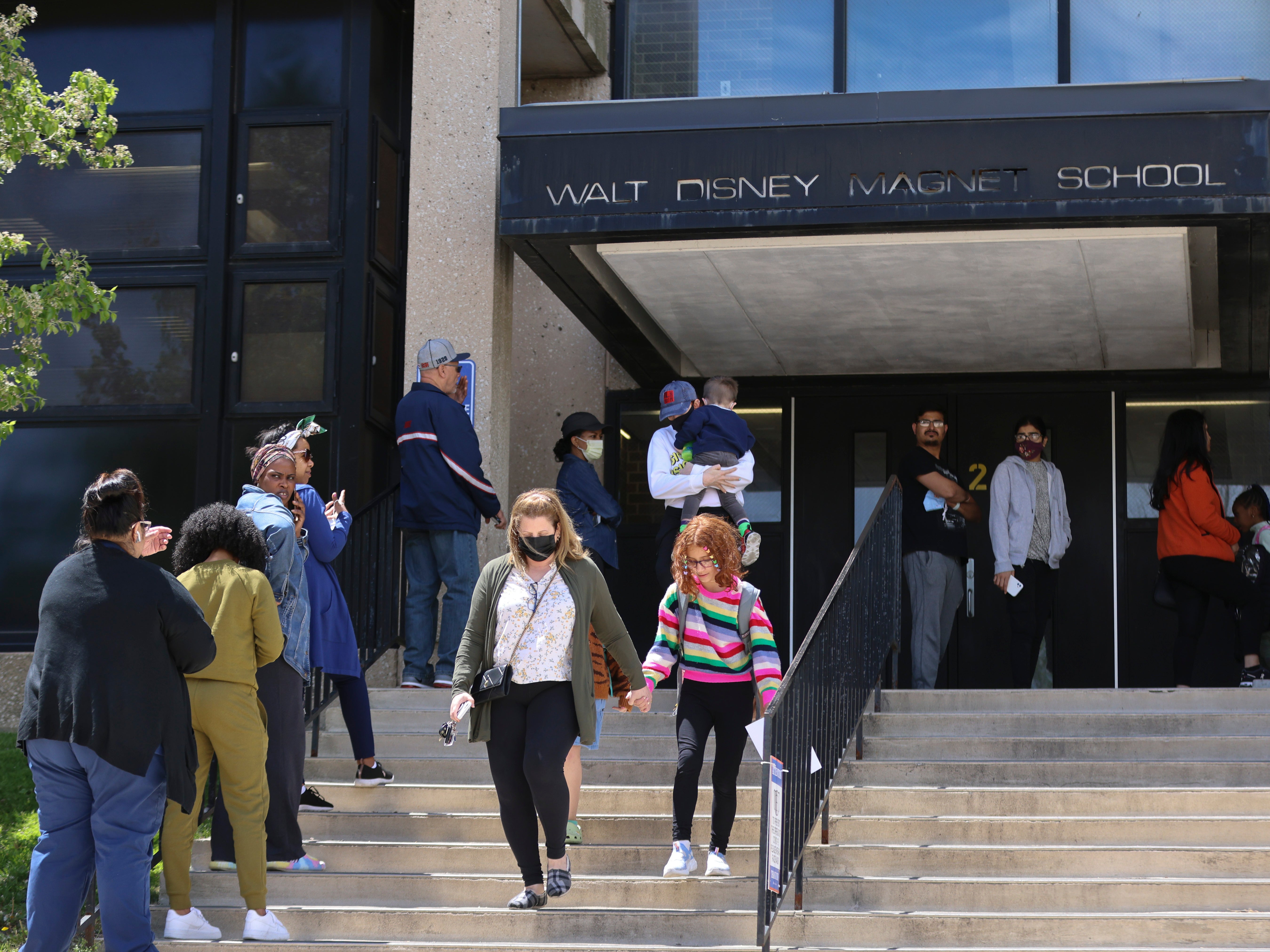 Parents wait to pick up their children at Walt Disney Magnet School in Chicago on Tuesday