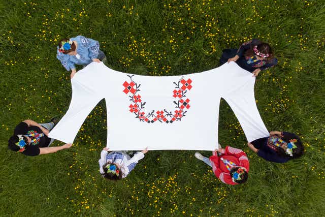 Kristina Korniiuk, 34, (second left) who is originally from Kyiv and fled the Ukraine following the Russian invasion, marks the Ukrainian celebration of Vyshyvanka Day with a giant traditional shirt Joe Giddens/PA)
