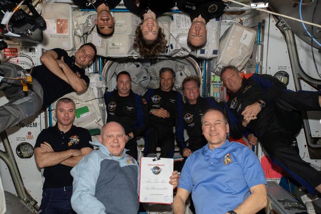 <p>The four members of the Axiom-1 mission occupy the center row in this image of the full 11-person crew aboard the ISS on 9 april 2022</p>