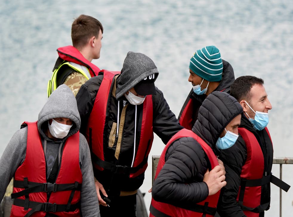 A group of people thought to be migrants are brought in to Dover, Kent, by military personnel, following a small boat incident in the Channel. Picture date: Thursday May 19, 2022. (Gareth Fuller/PA)