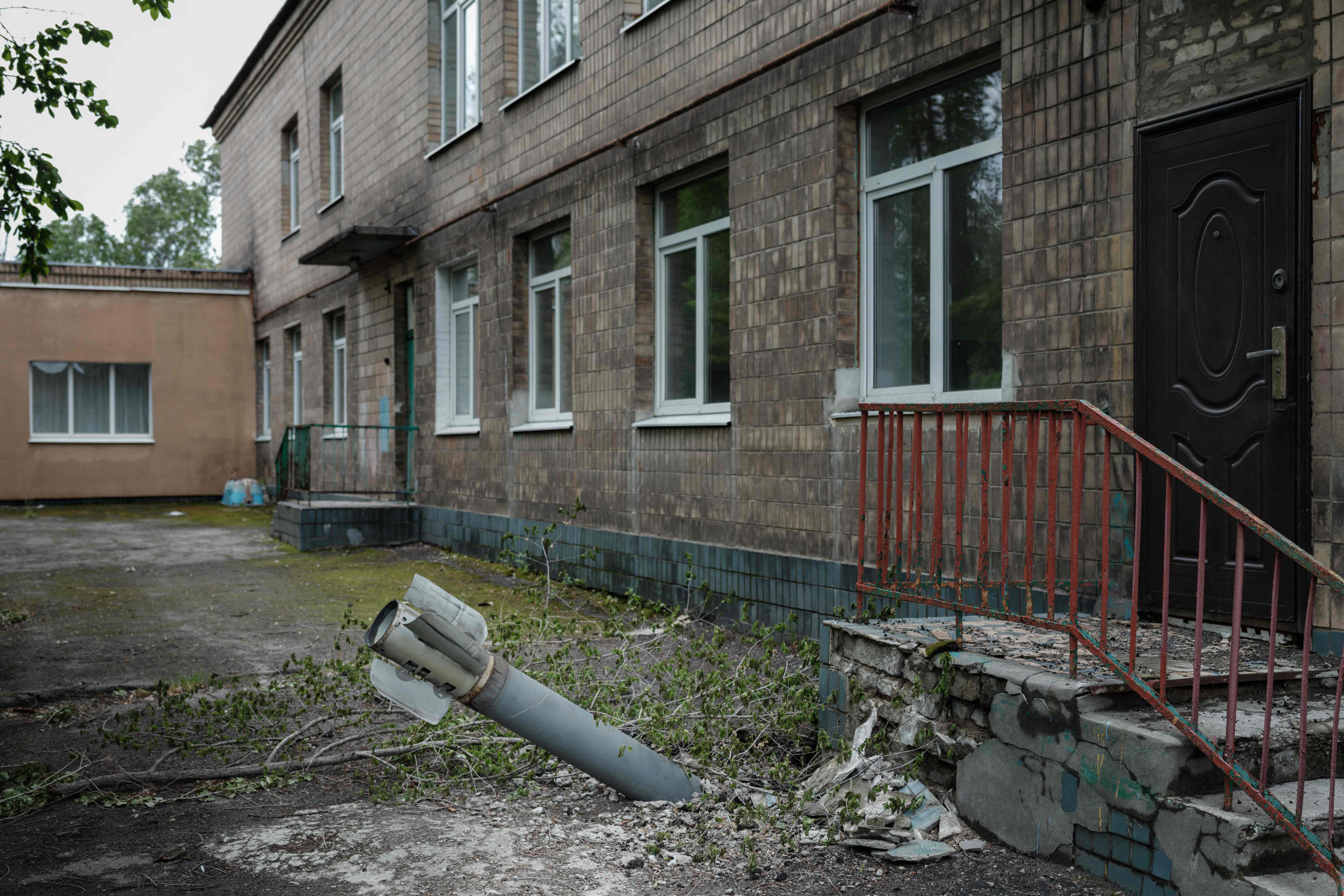 An unexploded ordnance is seen at a backdoor of a kindergarten where seven people have been sheltering in the basement for more than two months, in Lysychansk, eastern Ukraine