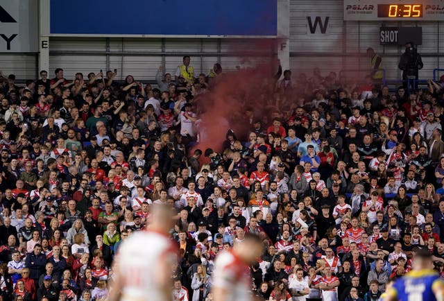 A flare is visible among the St Helens fans who packed the away end at The Halliwell Jones Stadium (PA Images/Zac Goodwin)