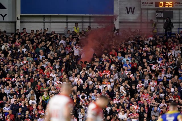 A flare is visible among the St Helens fans who packed the away end at The Halliwell Jones Stadium (PA Images/Zac Goodwin)