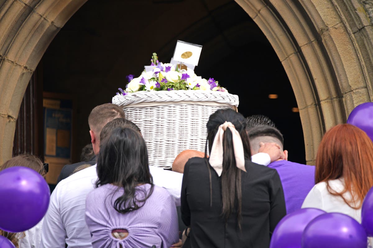 Mourners wearing purple pay respects to woman found dead in forest
