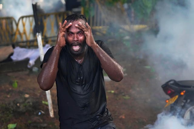 <p>An injured protester shouts in pain as police fire tear gas to disperse protesting members of the Inter University Students Federation during an anti government protest in Colombo on 19 May</p>
