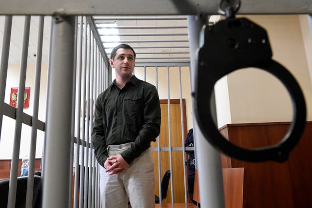 <p>US ex-marine Trevor Reed, charged with attacking police, stands inside a defendants' cage during a court hearing in Moscow on March 11, 2020</p>