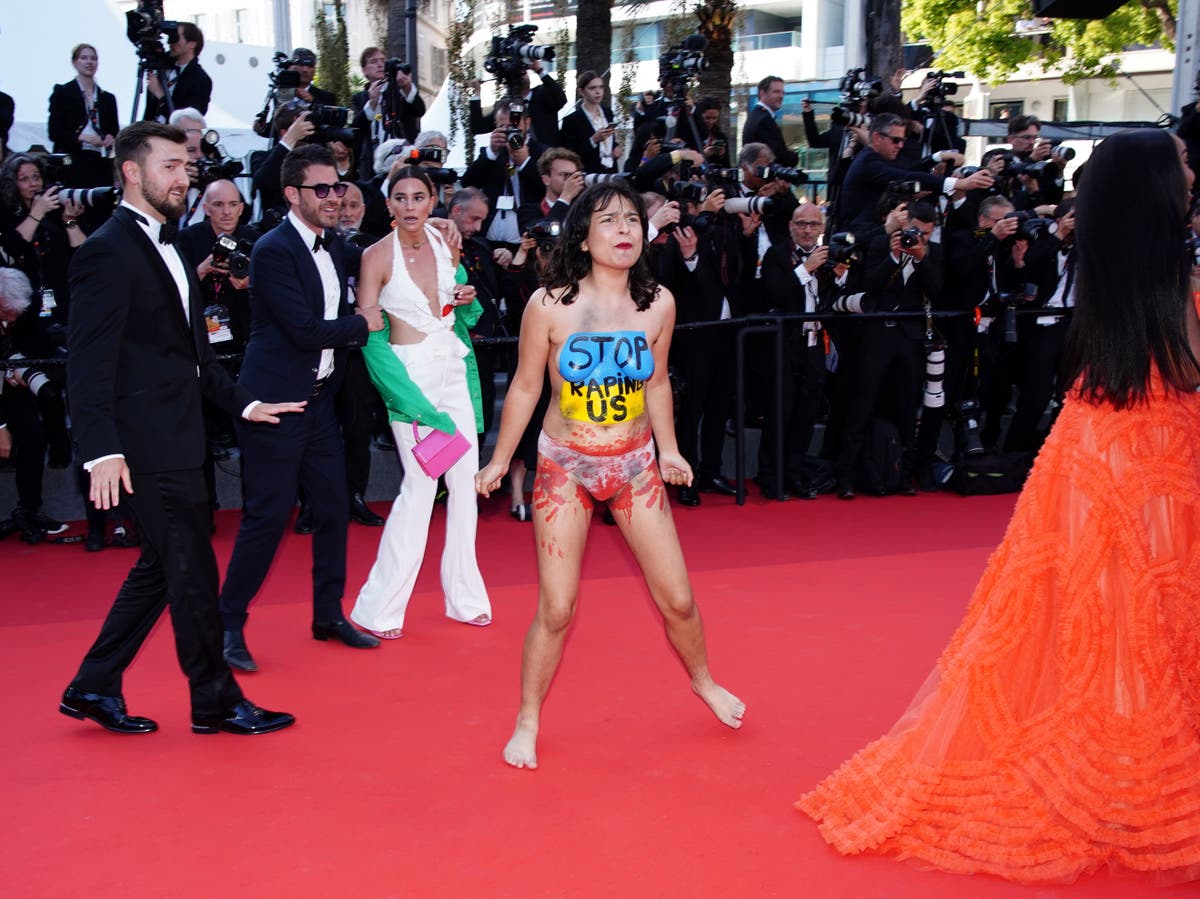 Ukraine protestor removed from Cannes by security after stripping on the red carpet