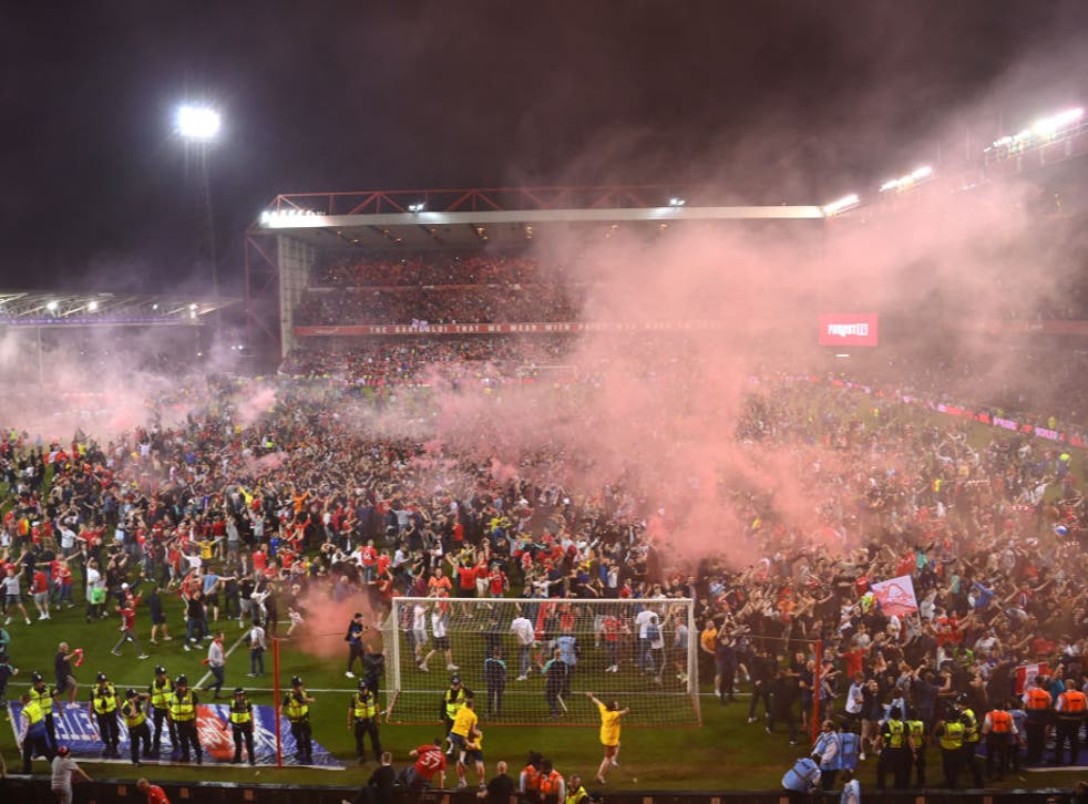 <p>Nottingham Forest fans celebrate on the pitch after the club’s play-off semi-final win</p>