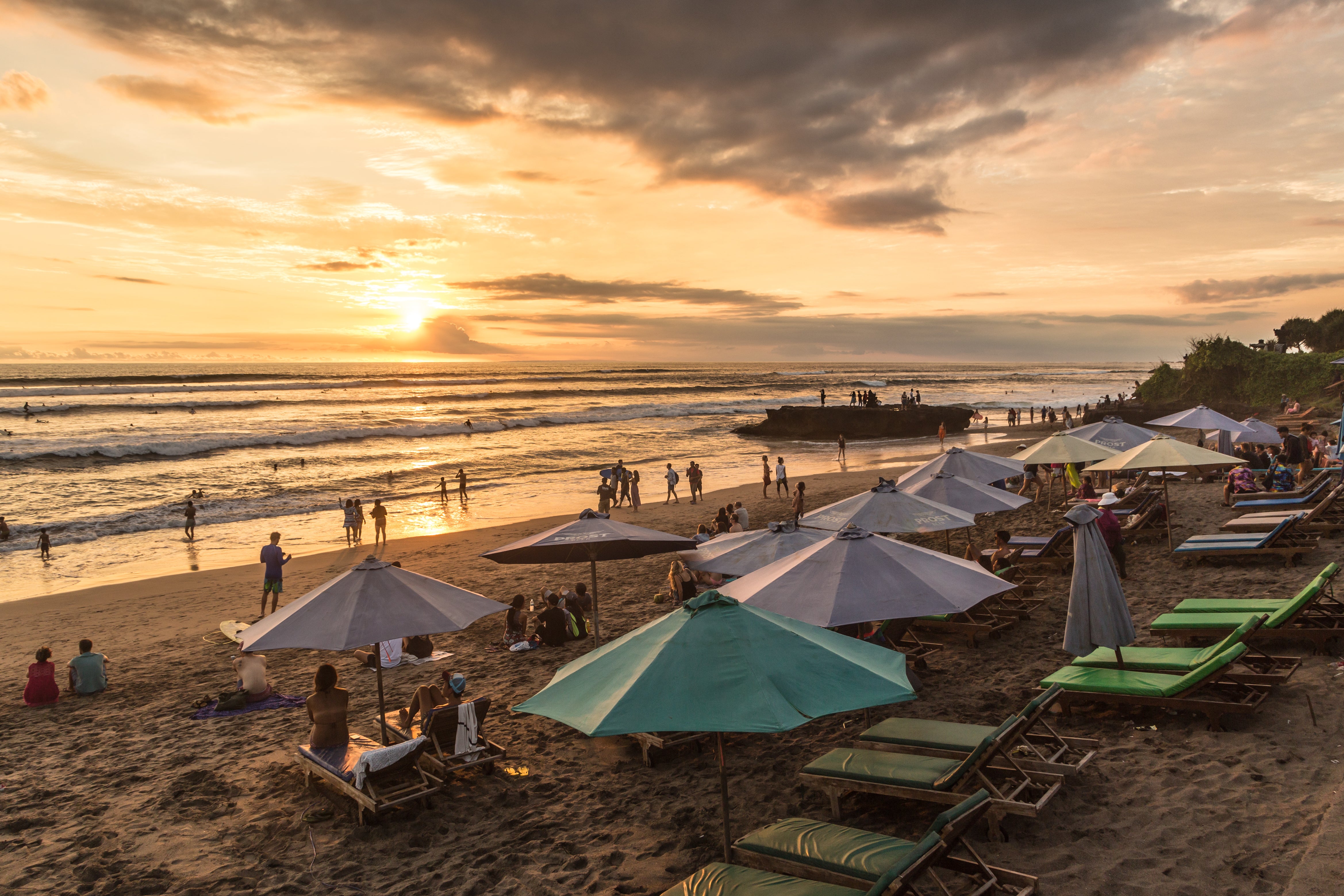 People enjoy the sunset over Canggu beach, north of Kuta and Seminyak, in Bali