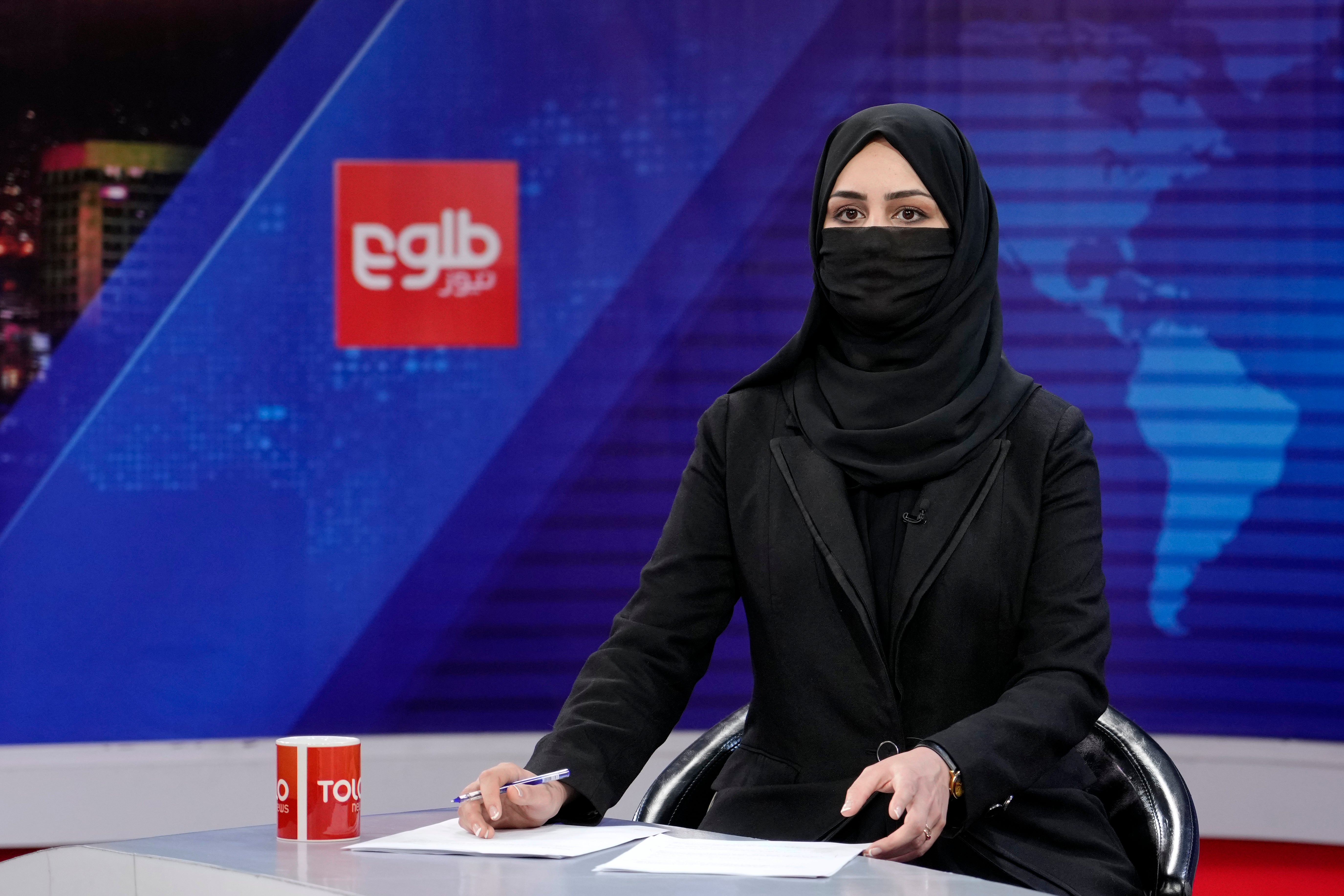 Khatereh Ahmadi a TV anchor wears a face covering as she reads the news on TOLOnews, in Kabul, Afghanistan.