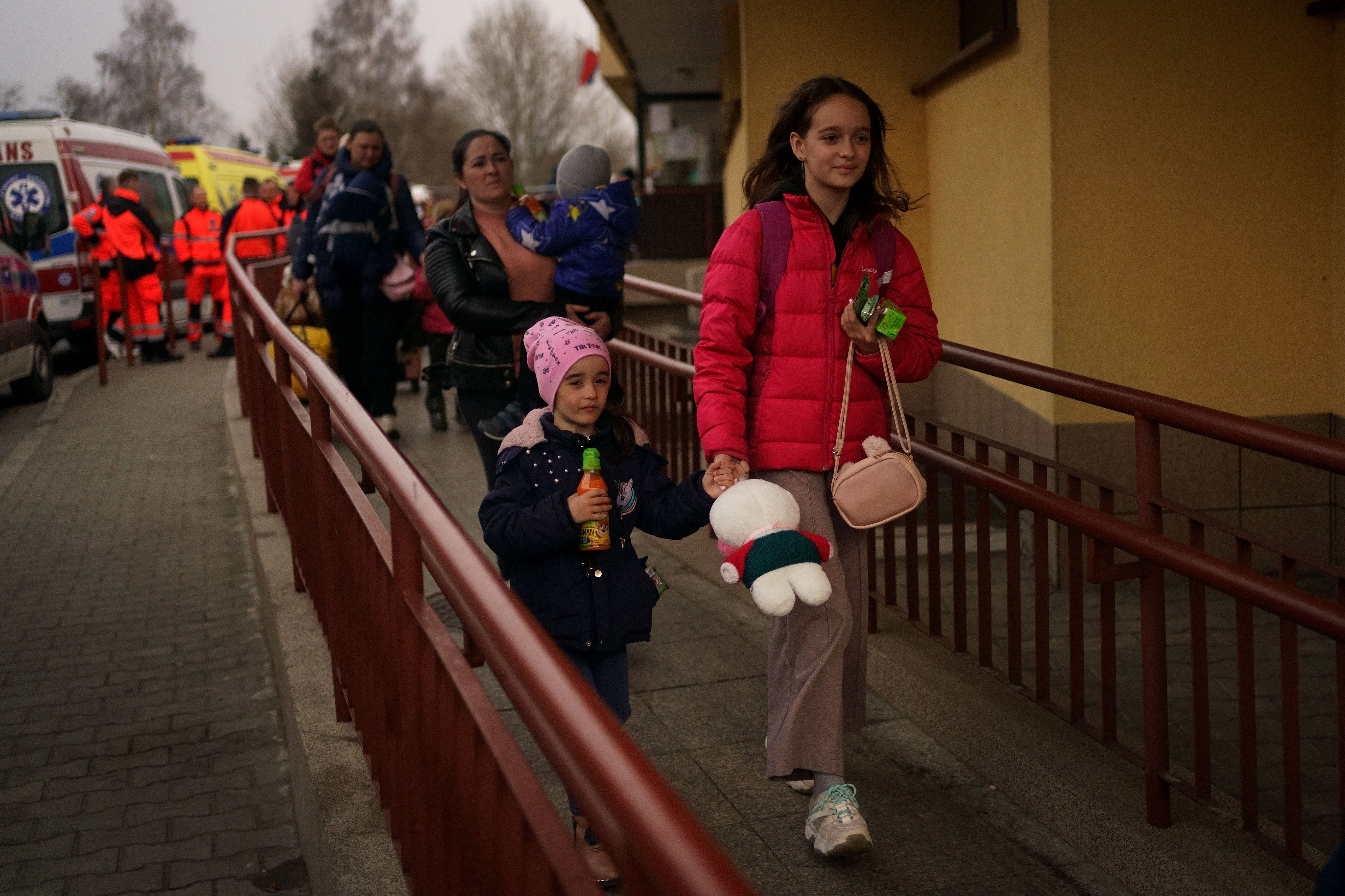Two Ukrainian children walk out of the customs office at Przemysl Glowny train station in Poland, after disembarking a train from Ukraine to flee the Russian invasion (Victoria Jones/PA)