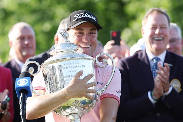 <p>Justin Thomas clutches the Wannamaker Trophy after his play-off win </p>