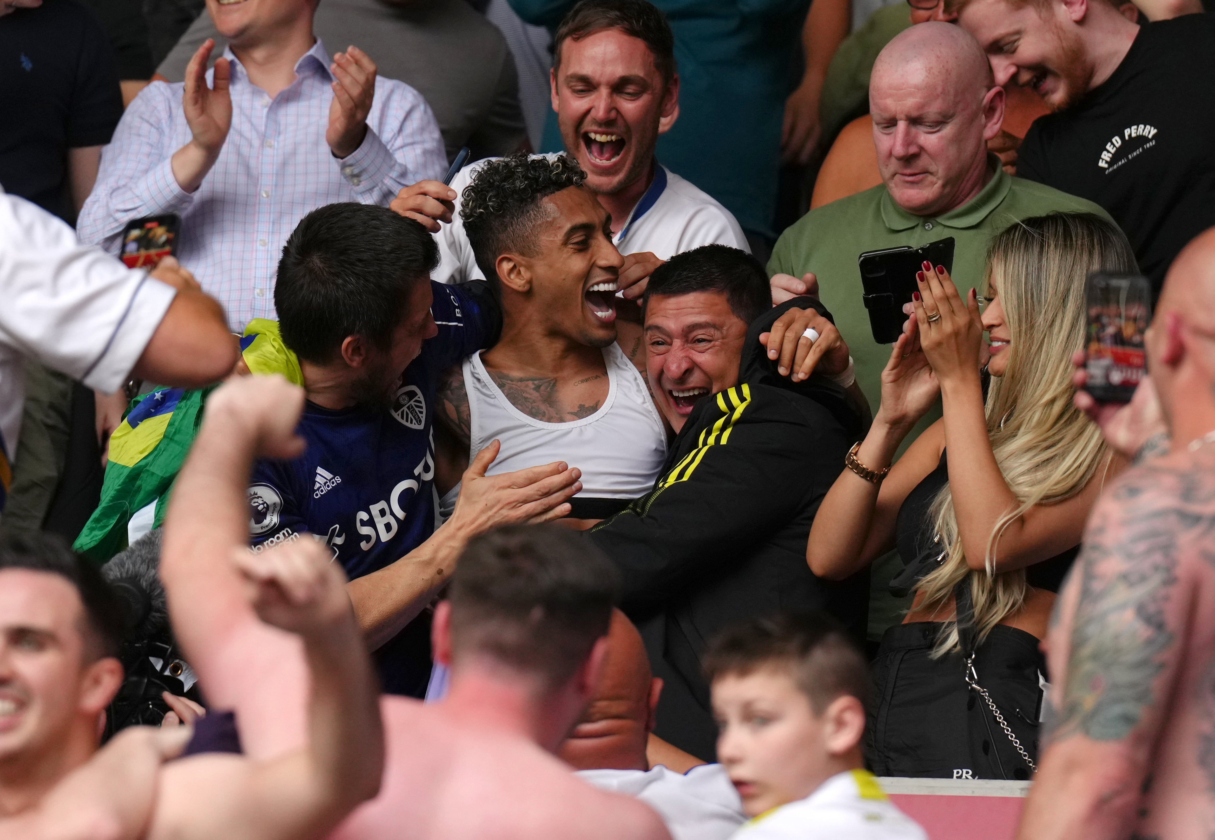 Raphinha celebrates Leeds’ survival in the stands with the fans (John Walton/PA)