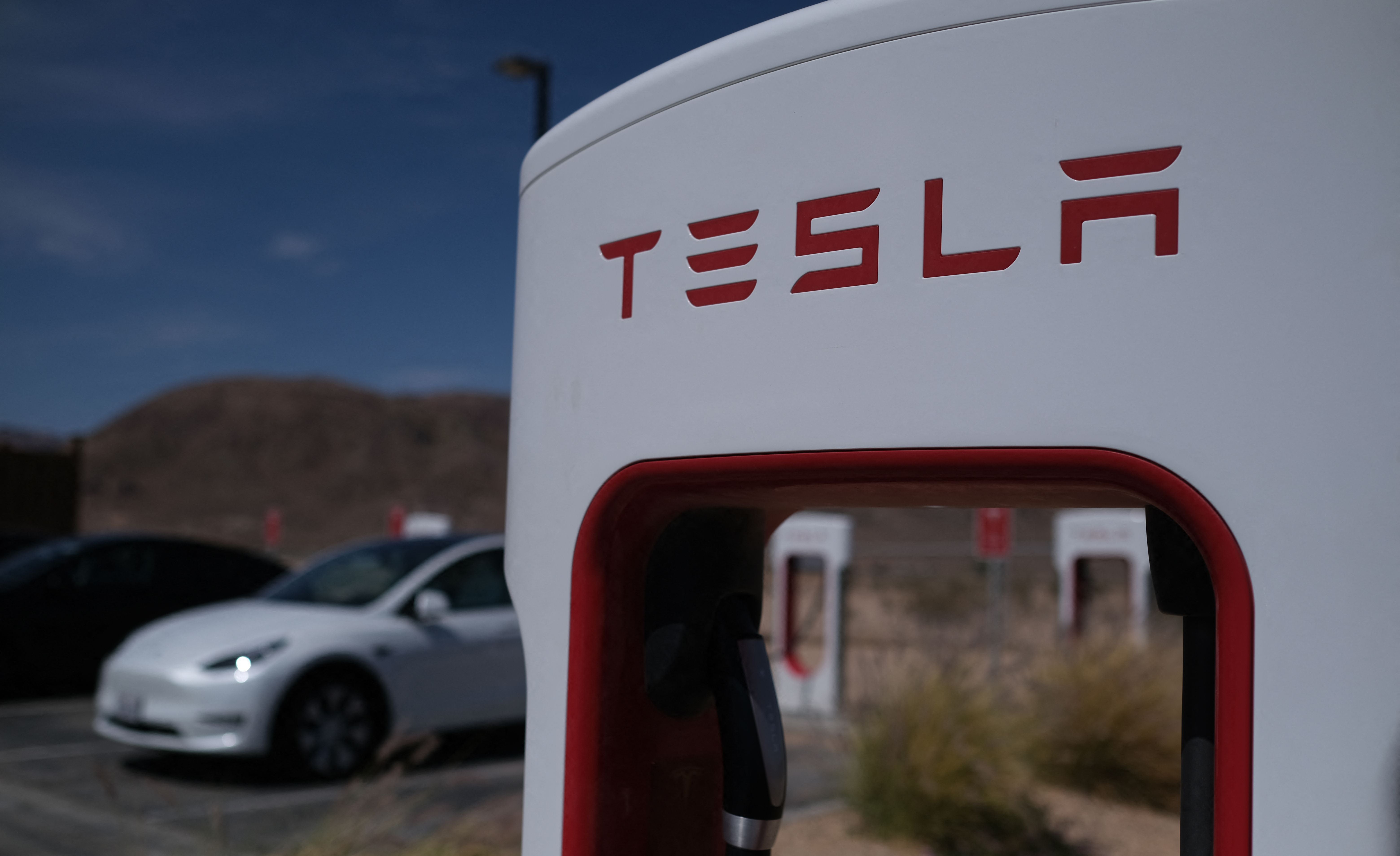 <p>Tesla cars sit at charging stations in Yermo, California</p>