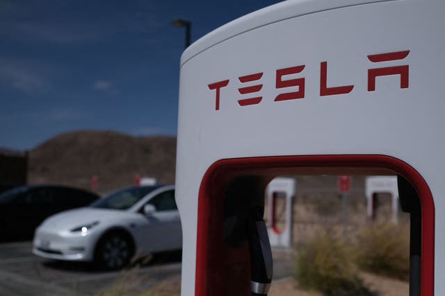 <p>File: Tesla cars sit at charging stations in Yermo, California</p>