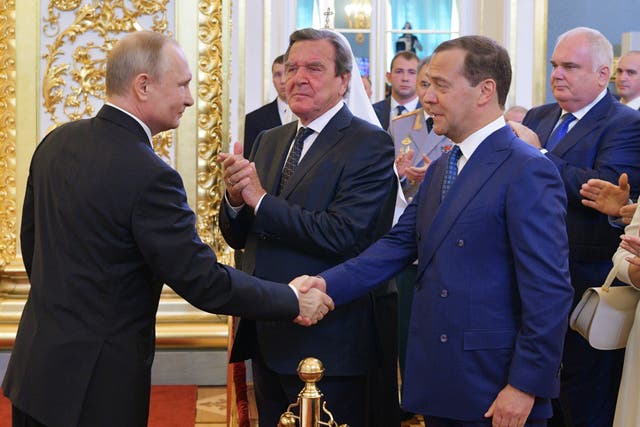 <p>Vladimir Putin [L] shakes the hand of his predecessor Dmitry Medvedev </p>