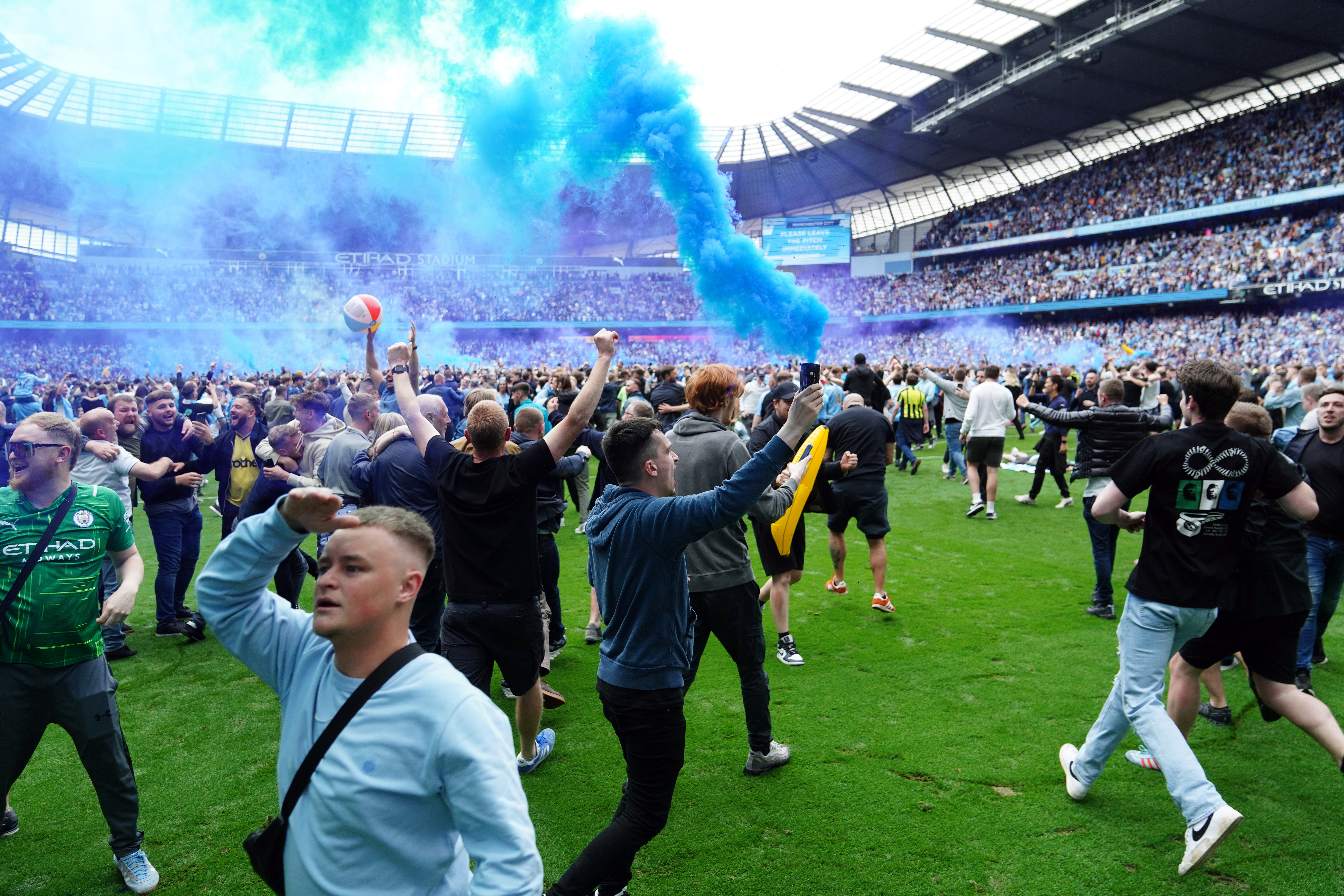 Manchester City fans invade the pitch (Martin Rickett/PA)