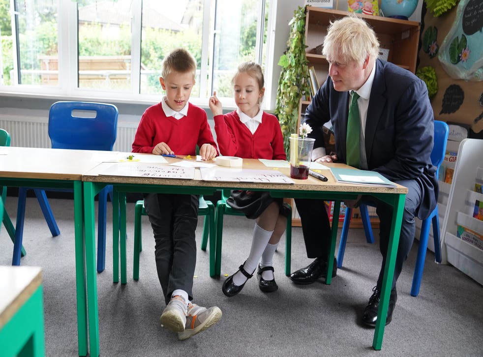 Prime Minister Boris Johnson meets Ukrainian refugees Bohdan and Liza, both seven, as they take part in a science lesson during his visit to St Mary Cray Primary Academy, in Orpington, to see how they are delivering tutoring to help children catch up following the pandemic (Stefan Rousseau/PA)