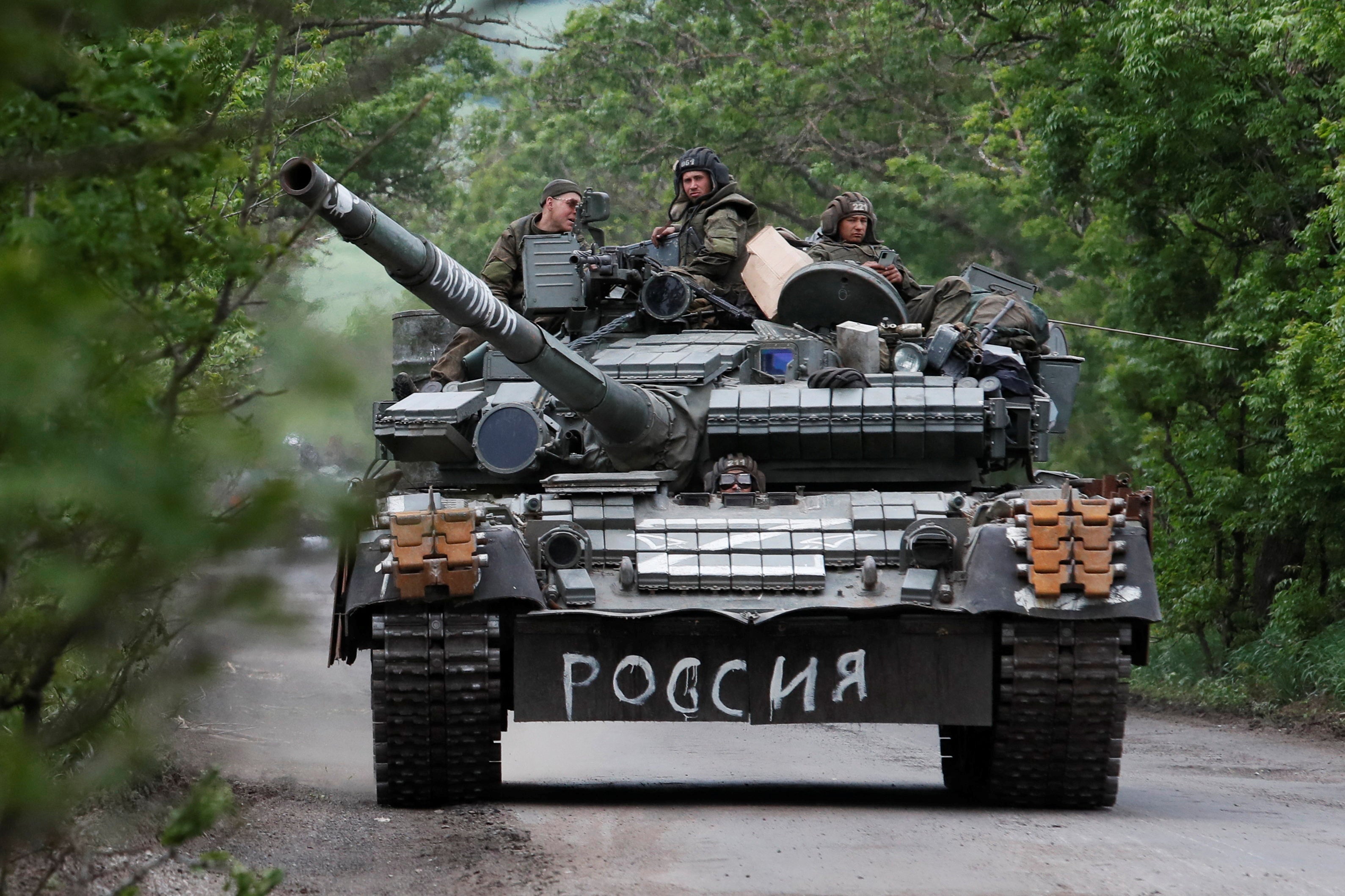 Service members of pro-Russian troops drive a tank during Ukraine-Russia conflict in the Donetsk region, Ukraine May 22, 2022. The writing on the tank reads: “Russia”