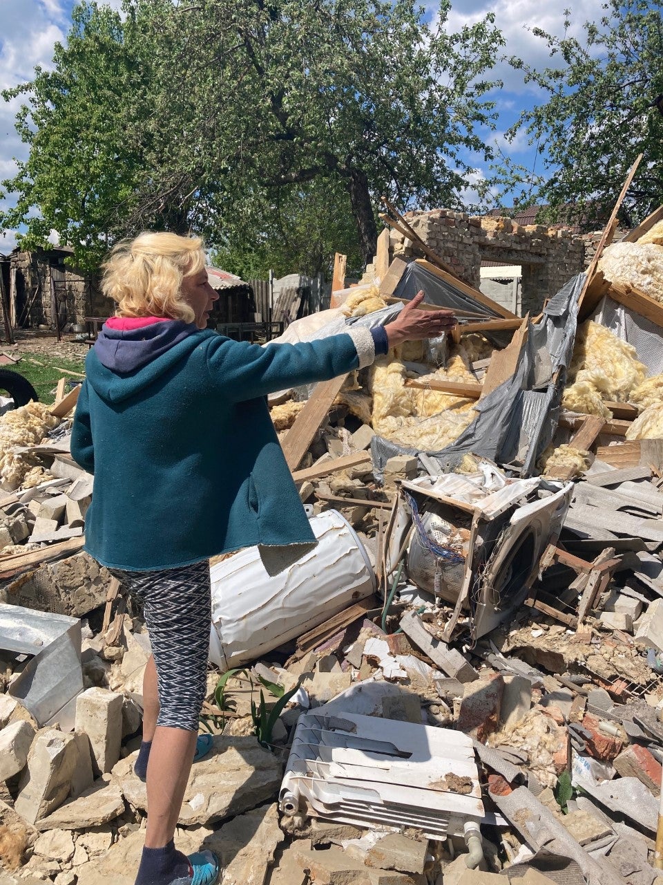 Vasilia Kirilev points to what is left of her home in Vilkhivka near Kharkiv