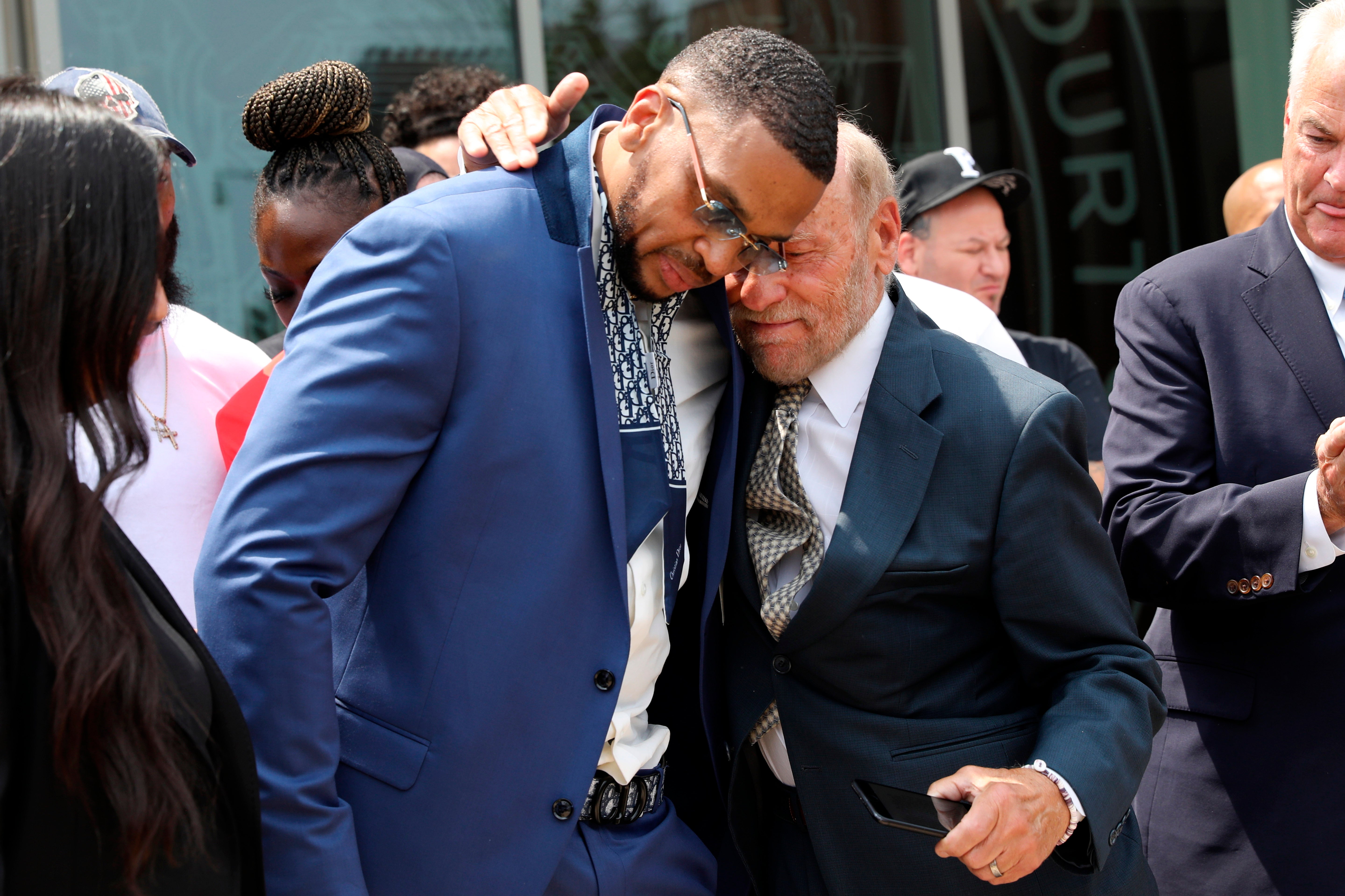 Grant Williams, left center, is embraced by his attorney Irving Cohen after his murder conviction is vacated, July 22, 2021, in New York