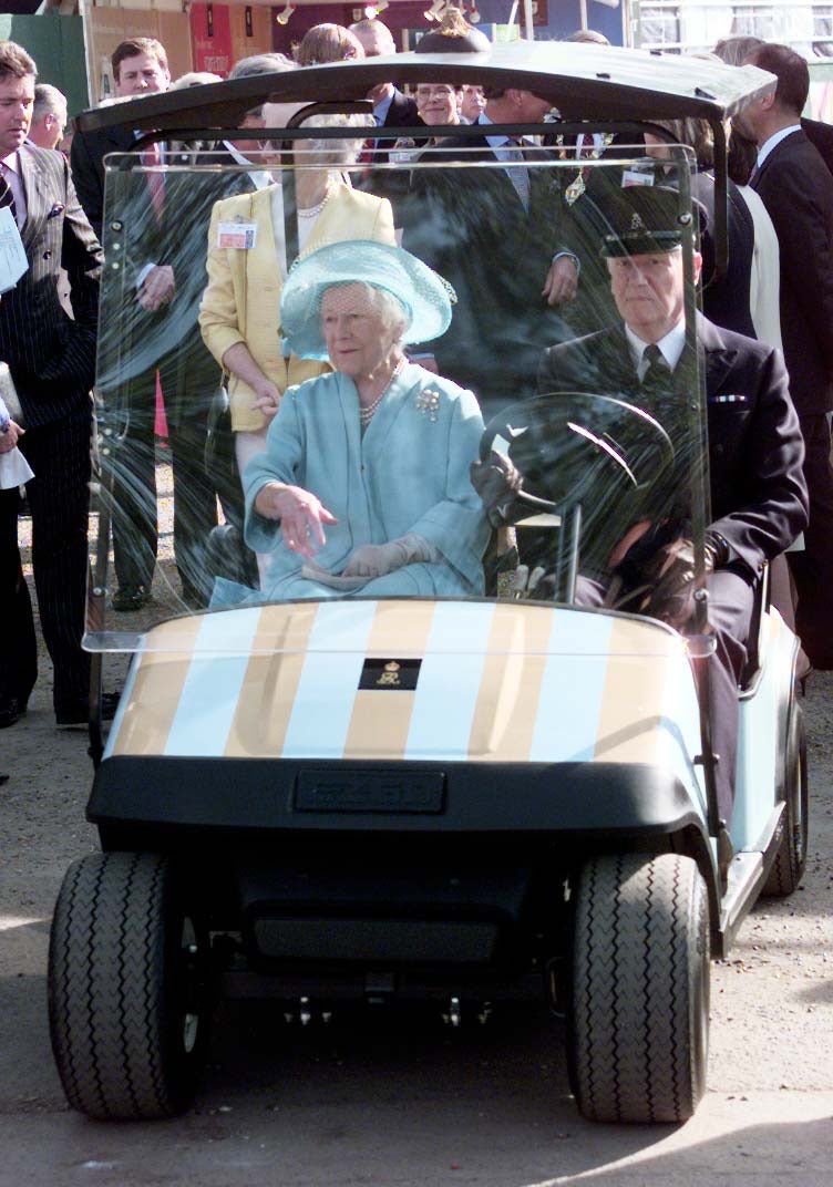 The Queen Mother at the Chelsea Flower Show in her trademark Queen Mum Mobile, a golf cart painted in her light blue and gold candy-stripe racing colours in 2001 (Peter Jordan/PA)