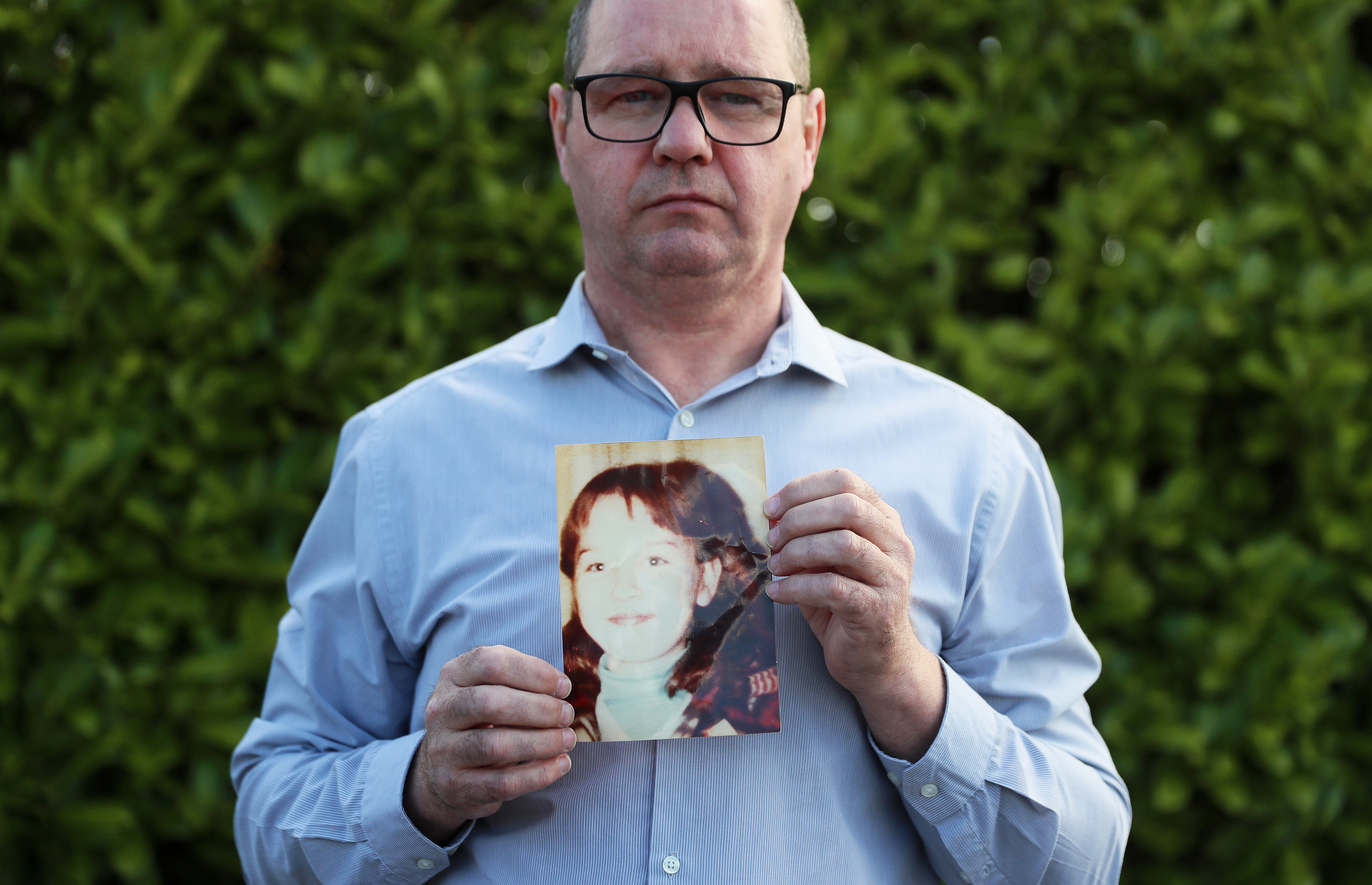 Mark Kelly holds a photograph of his 12-year-old sister Carol-Ann (Brian Lawless/PA)