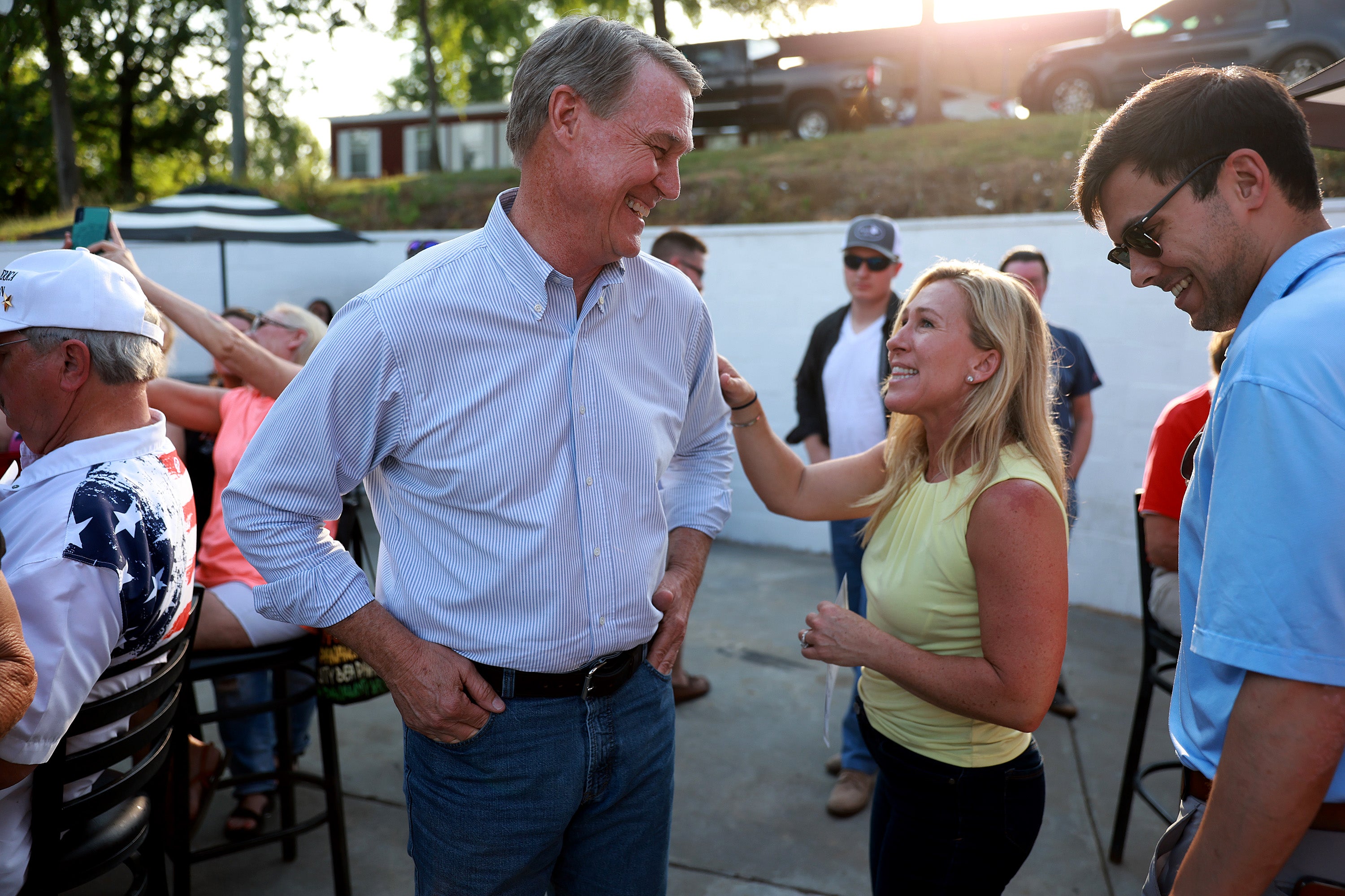 Republican gubernatorial candidate David Perdue and Rep Marjorie Taylor Greene speak to each other during a Bikers for Trump campaign event held at the Crazy Acres Bar & Grill on May 20, 2022 in Plainville, Georgia. Former U.S. Sen. David Perdue (R-GA) is running to unseat Georgia Gov. Brian Kemp and Rep. Greene is running for a second congressional term in the state's primary. (Photo by Joe Raedle/Getty Images)