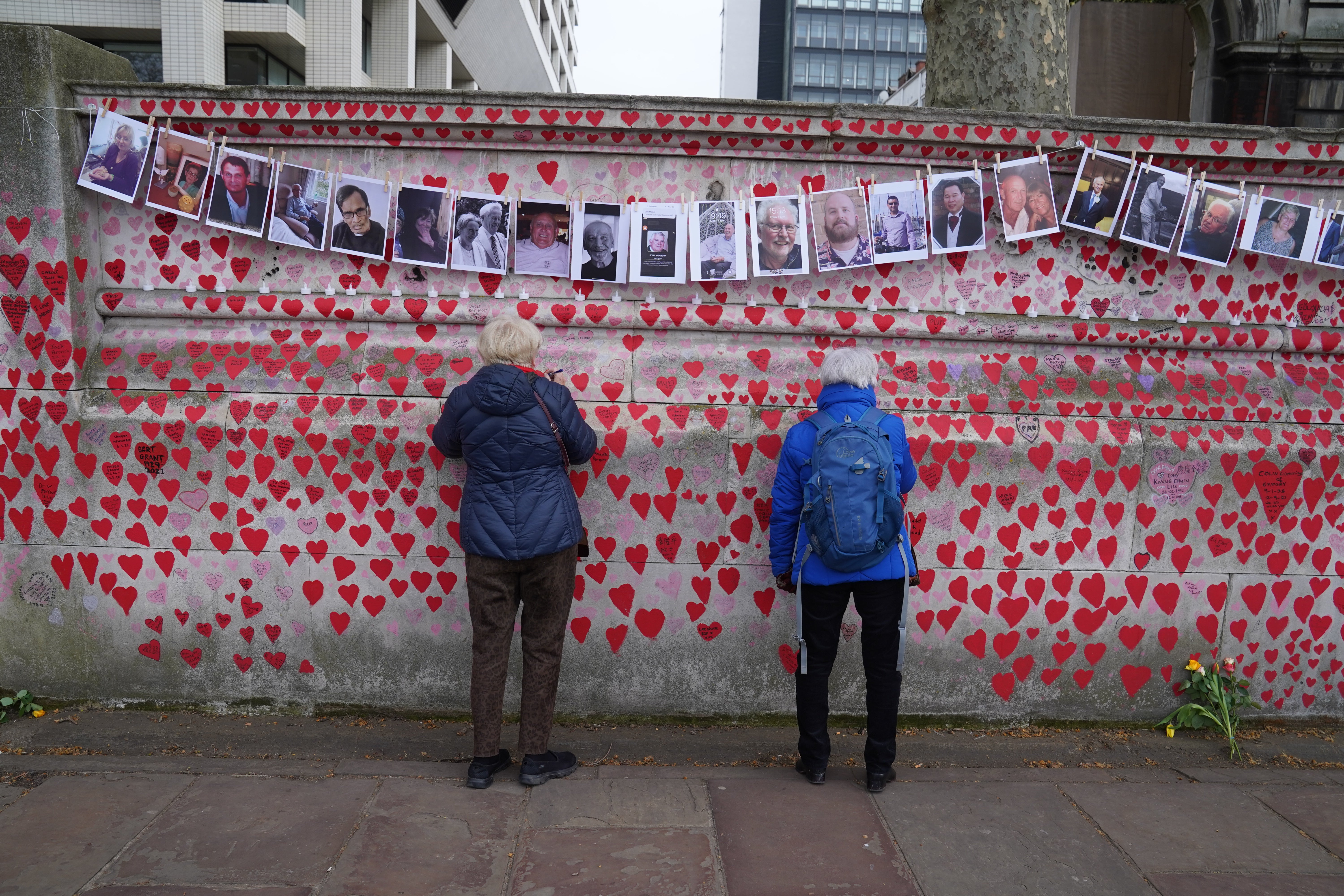 Bereaved families by the Covid memorial wall in central London (Stefan Rousseau/PA)