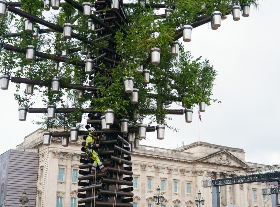 A construction worker climbs the Queen’s Green Canopy Tree Of Trees installation, designed by Thomas Heatherwick (Dominic Lipinski/PA)