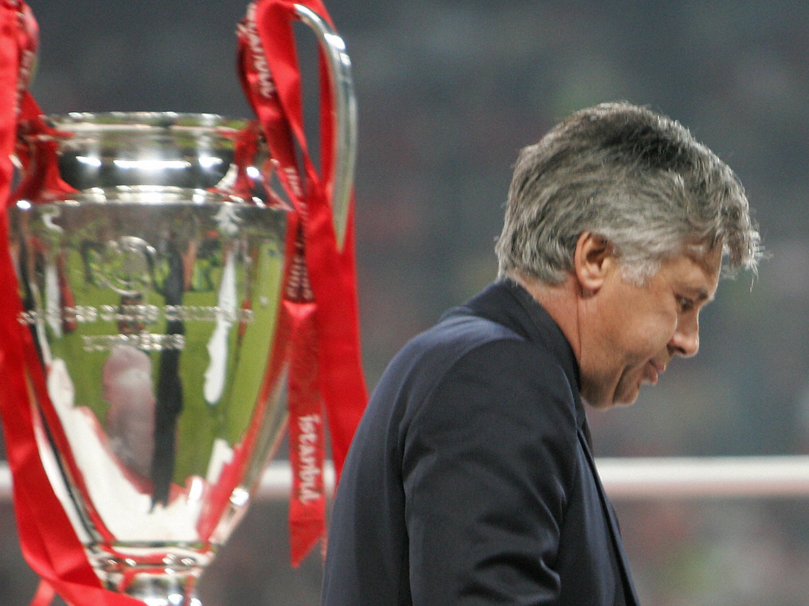 Carlo Ancelotti walks past the Champions League trophy in 2005