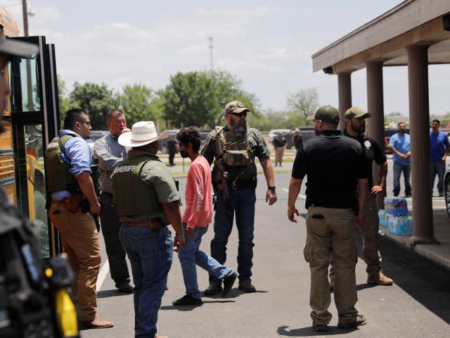 <p>Children get on a school bus as law enforcement personnel guard the scene of a shooting near Robb Elementary School in Uvalde, Texas, U.S. May 24, 2022</p>