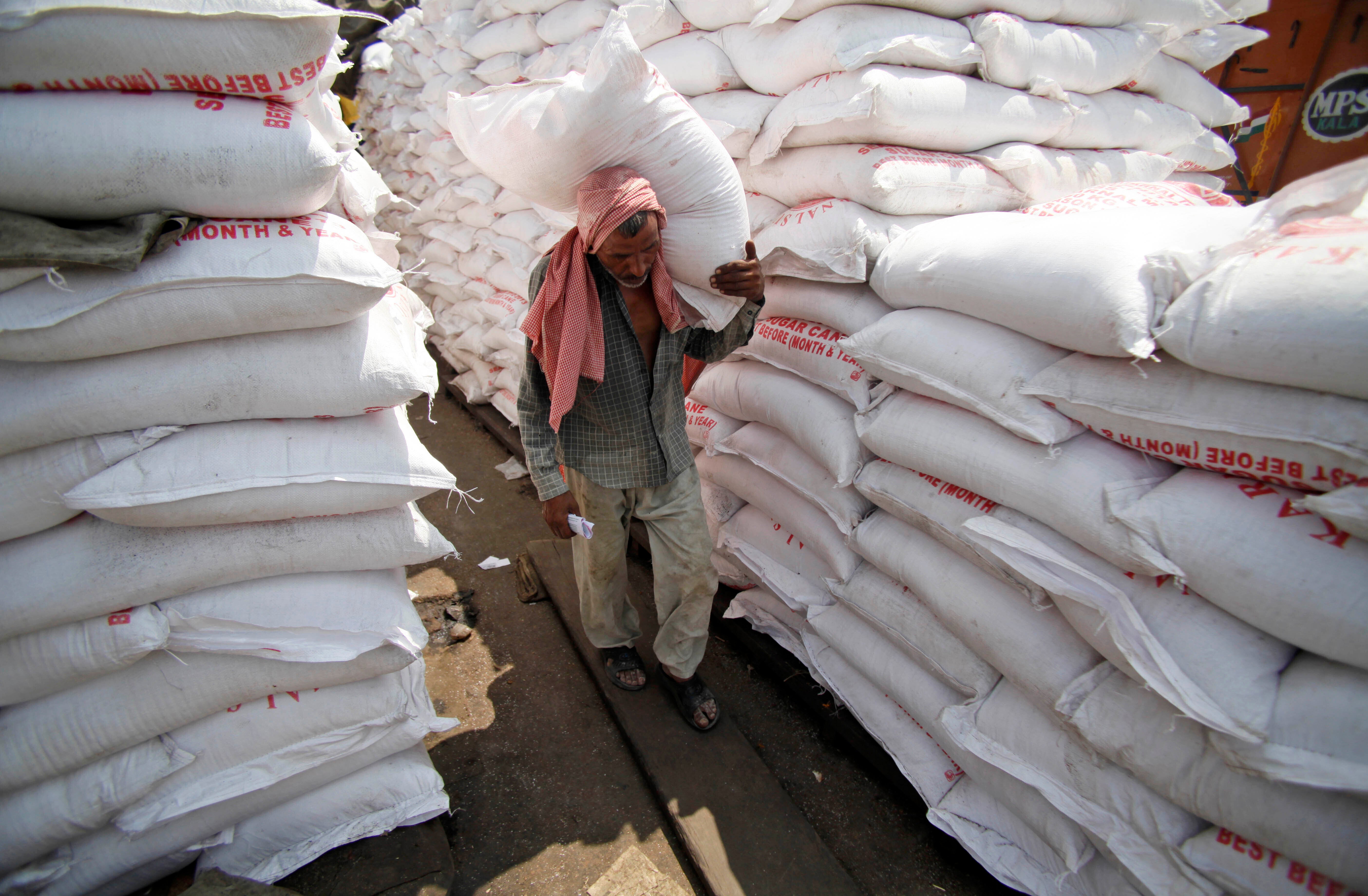 <p>A labourer carries a sack of sugar at a warehouse in Jammu, India</p>