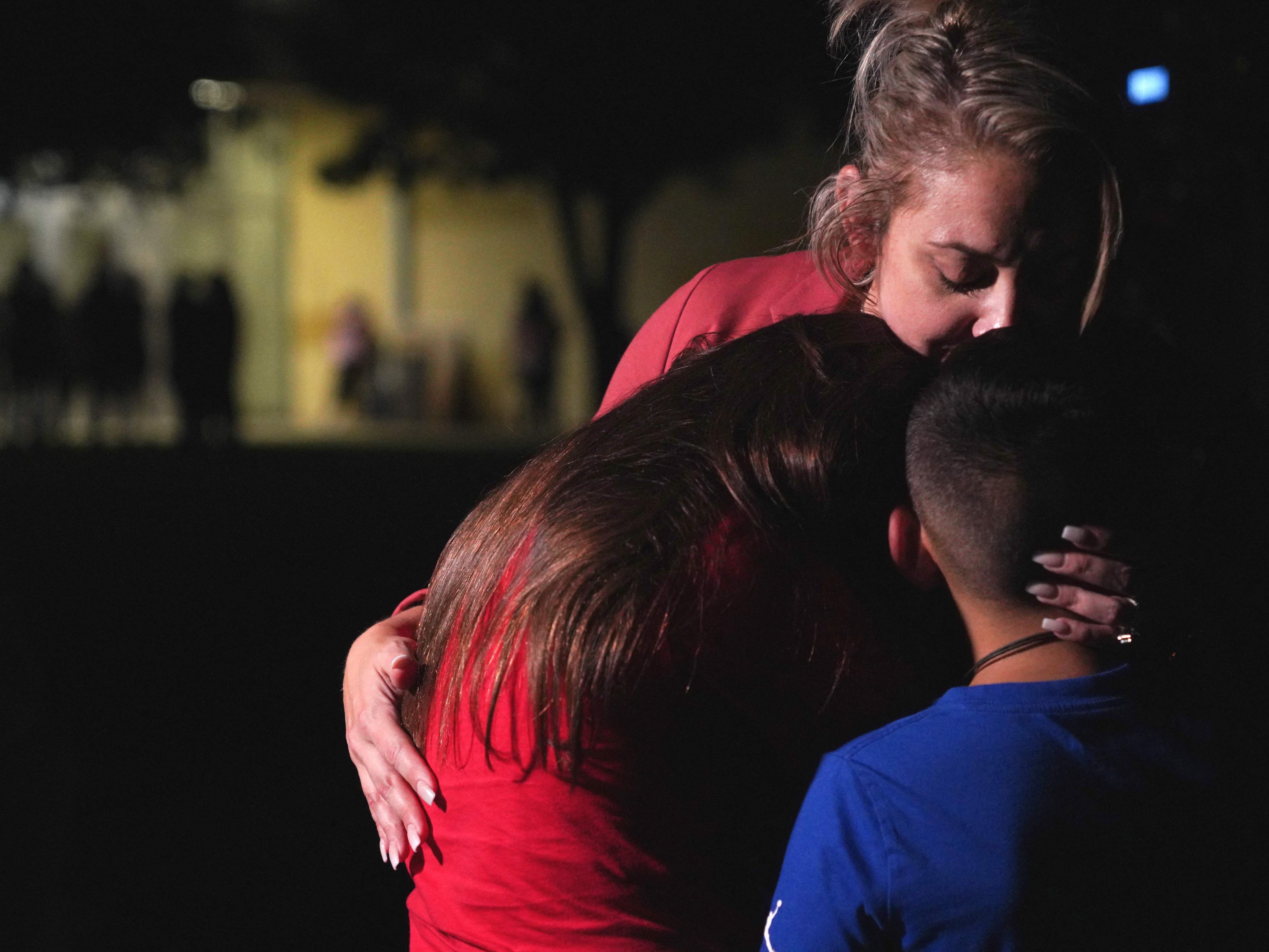 Families hug outside a centre where grief counseling will be offered in Uvalde following a school shooting
