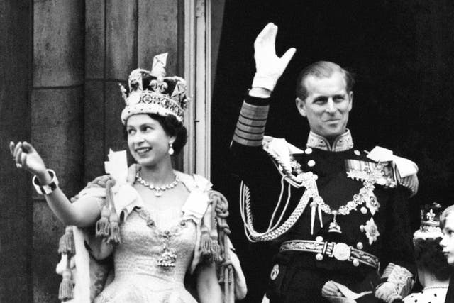 Queen Elizabeth II and the Duke of Edinburgh wave from the balcony at Buckingham Palace after the Coronation in 1953 (PA Archive)