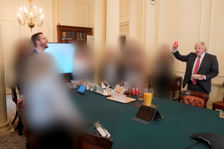 Boris Johnson raises a can of beer as he meets with people in the cabinet room on his birthday. Also pictured is cabinet secretary Simon Case