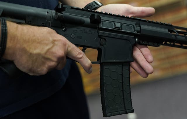 <p>A customer handles an AR-15 rifle at a shop in New York</p>