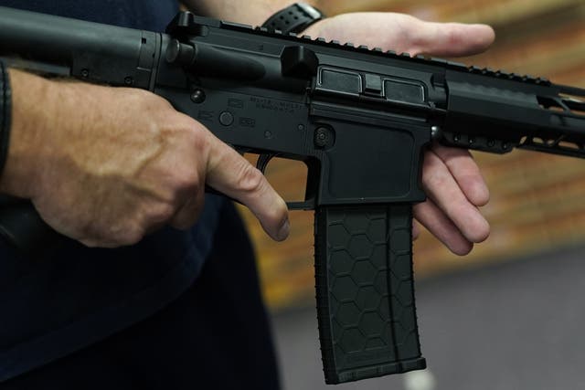 <p>A customer handles an AR-15 rifle at a shop in New York</p>