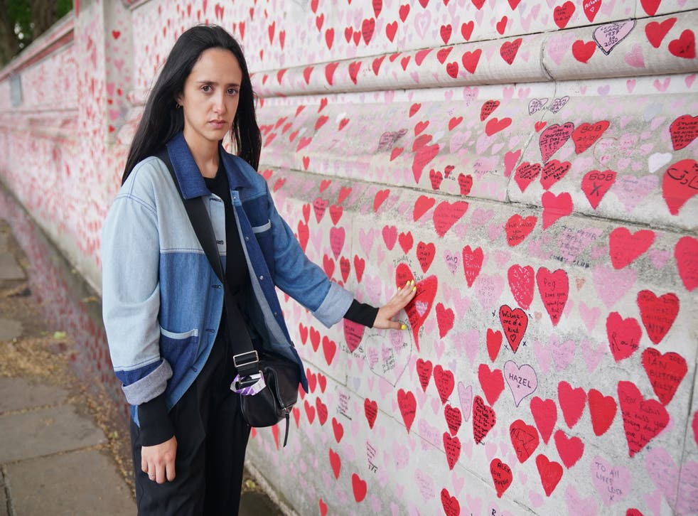 Safiah Ngah, who lost her father to Covid, with the heart she painted for him at the National Covid Memorial Wall in central London (Jonathan Brady/PA)