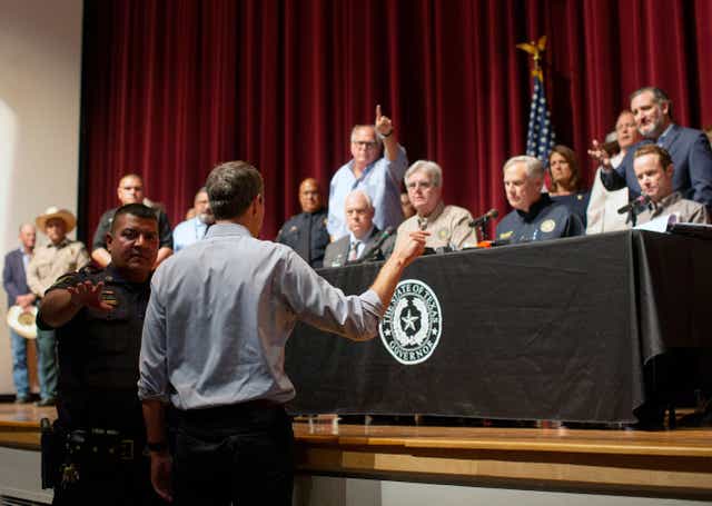 <p>Dan Patrick, centre in tan shirt, watches as Beto O’Rourke interrupts press conference on school shooting </p>