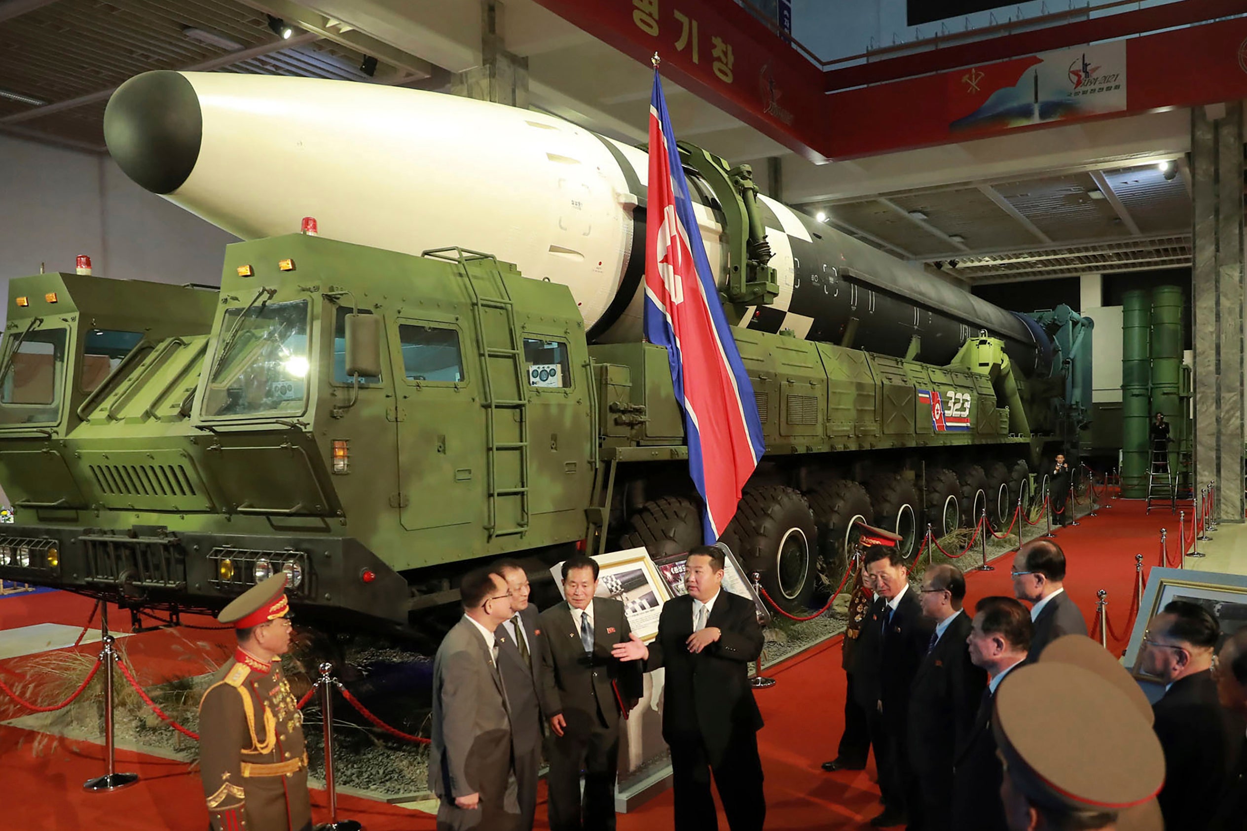 File photo: North Korean leader Kim Jong-un (centre) speaks in front of what the North says is an intercontinental ballistic missile displayed at an exhibition of weapons systems in Pyongyang on 11 October 2021