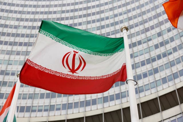 <p>The Iranian flag waves in front of the International Atomic Energy Agency headquarters</p>