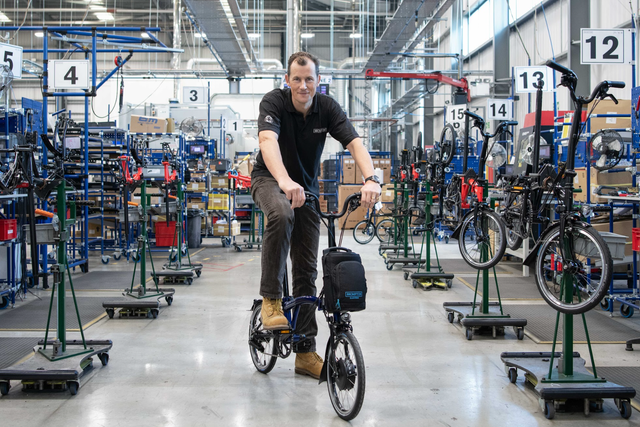 <p>Will Butler-Adams on an electric version of the Brompton at the London factory</p>