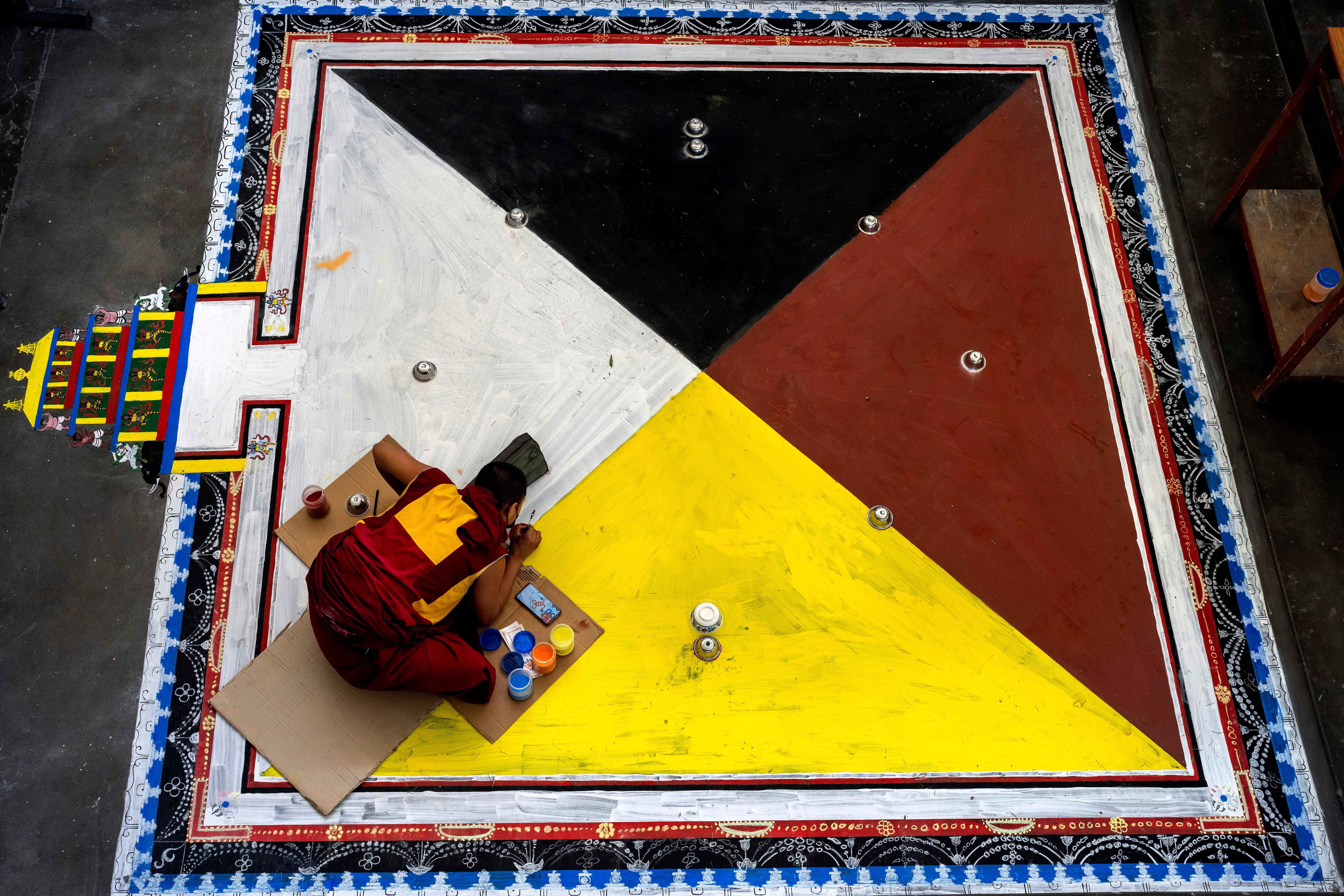 <p>File photo: An exile Tibetan Buddhist monk creates a traditional motif on the floor in preparation for ritual prayers in Dharmsala, India on 20 May</p>