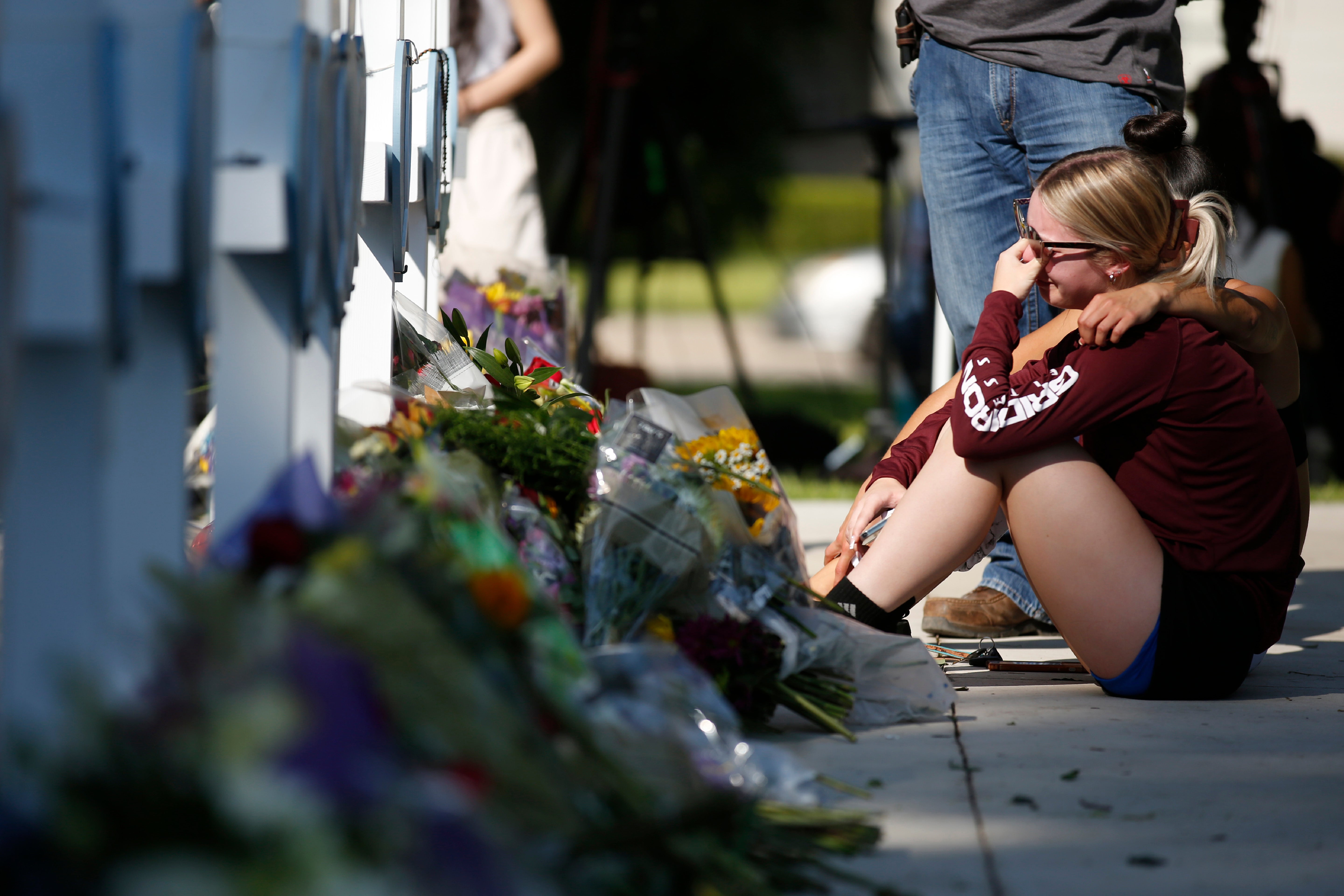 A woman reacts as she pays her respects at a memorial site for the victims killed in this week’s elementary school shooting in Uvalde, Texas, Thursday, 26 May 2022