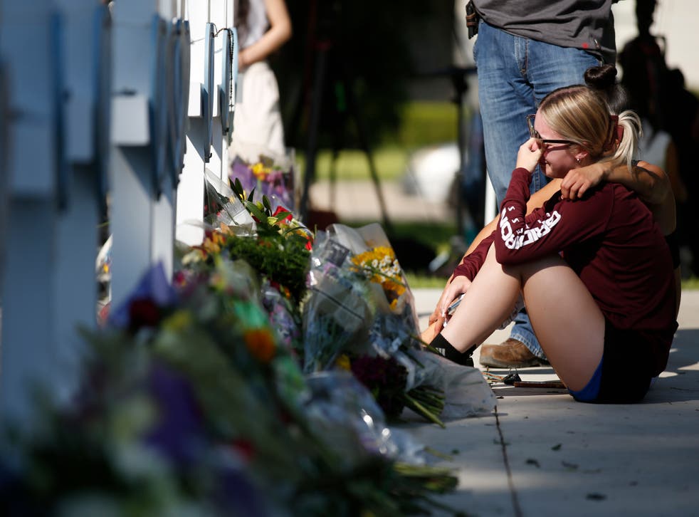<p>A woman reacts as she pays her respects at a memorial site for the victims killed in this week’s elementary school shooting in Uvalde, Texas, Thursday, 26 May 2022</p>