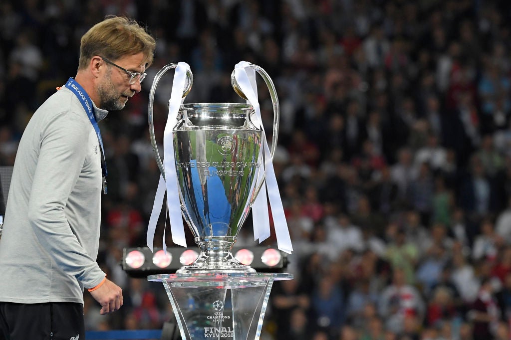 So close... a despondent Klopp passes the Champions League trophy after defeat in 2018